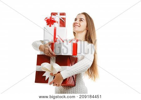Beautiful smiling girl with a long hair posing on the camera in studio and holding christmas gift isolated on white background. Close-up of gifts. Holiday concept.