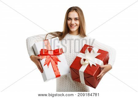 Pretty cutie girl with a long hair posing on the camera in studio and holding christmas gift isolated on white background. Close-up of gifts. Holiday concept.
