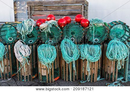 Lobster traps standing on a pier prepared for fishing with ropes and buoys in a Norwegian fishing village