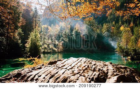Autumn time at romantic forest lake blausee, one of the best known mountain lakes in Switzerland.
