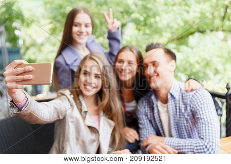 Friends who have fun in a cafe. Do selfie. Blurred background. Concept of leisure.