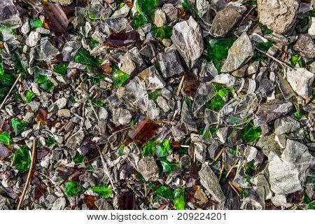 Shards of glass on shards of stone. Glass debris. Broken bottles. Background and texture