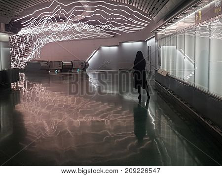 STOCKHOLM SWEDEN OCT 14 2017: Subway station Odenplan decorated with neon light in the ceiling and silhouette of a woman dressed in black in Stockholm October 14 2017