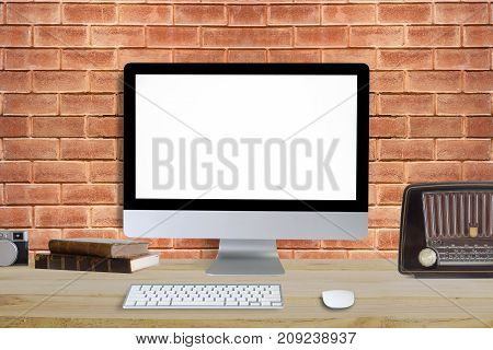 Computer desktop PC and decoration object on workspace with wood table and brick wall on backgroundMockup concept.