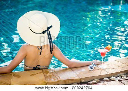 Women wearing bigini or swimware suits swimming pool Drinking water melon smoothie at the resort town of Pattaya in Thailand.