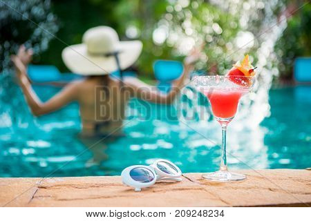 Women wearing bigini or swimware suits swimming pool Drinking water melon smoothie at the resort town of Pattaya in Thailand.