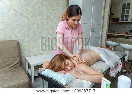 Beautiful young girl having massage in spa salon