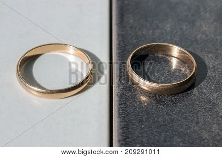 Two separate wedding rings on a black and white background. Concept - differences opposites and separation.
