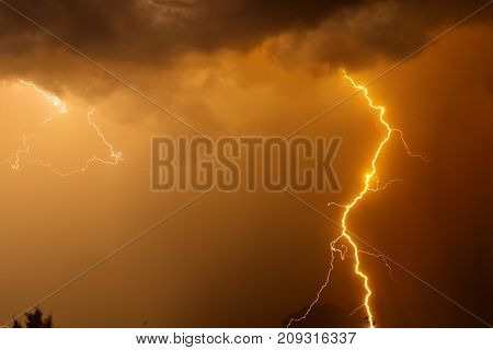 Fork Lightning Over Dark Orange Sky On Stormy Day