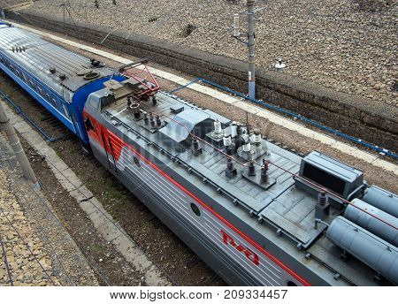 Voronezh, Russia - June 14, 2017: Electric locomotive RZD carries a passenger train a top view
