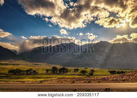 Play of lights and clouds before sunset above Sierra Nevada from route 395 in California, USA