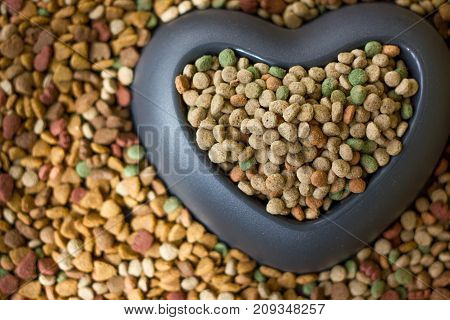 Dry pet food with big heart bowl and place for your text