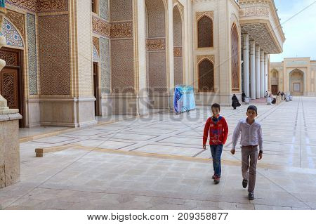 Fars Province Shiraz Iran - 19 april 2017: Shah Cheragh Shrine Two Iranian teenagers cross the courtyard of the mosque.
