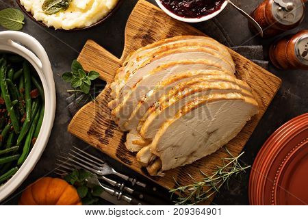 Sliced roasted tukey breast for Thanksgiving or Christmas dinner with side dishes overhead shot