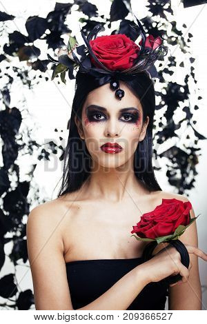 pretty brunette woman with rose jewelry, black and red, bright make up kike a vampire closeup red lips, halloween concept