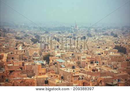 Old city streets and many stone houses at eveninf fog. Jaisalmer of India