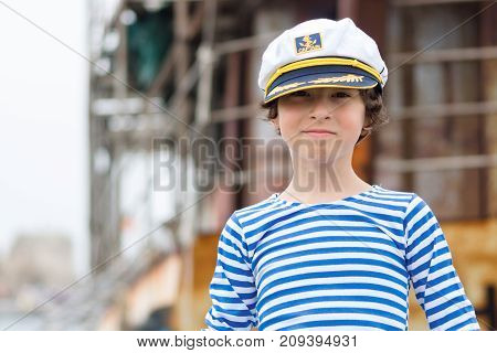 Portrait of a boy in a striped long sleeve T-Shirt (Telnyashka) and captain's cap.