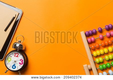 Collage with round clock pencil and nootbook on orange background time concept.
