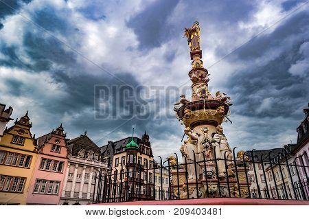 View of Hauptmarkt square in Trier, with historic fountain dating from 1595. Colorful facades in the central square Hauptmarkt with the monuments Petrusbrunnen and Market Cross