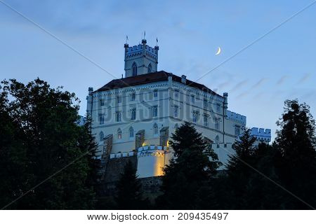 TRAKOSCAN CROATIA 27 June 2017: The moon is visible in the evening over historic Trakoscan Castle in Trakoscan Croatia.