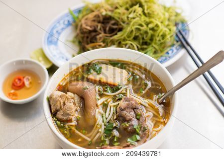 Vietnamese noodle soup Bun Bo Hue with fish source