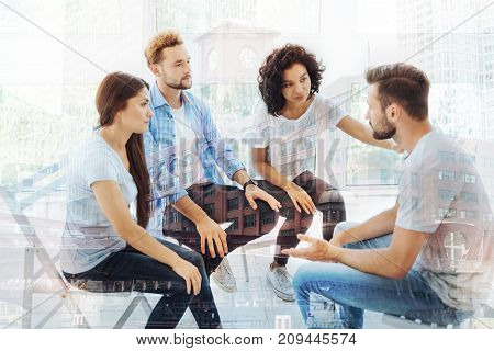 Having problems. Careful colleagues giving support to their friend while sitting in front of him and expressing sympathy
