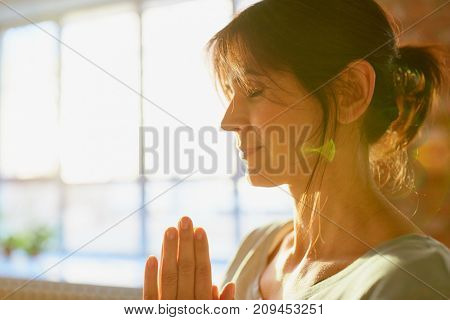 religion, faith, harmony and people concept - close up of yogi woman meditating at yoga studio