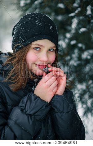 The girl pressed a small Christmas tree toy to her face. The child is happy with the gift.
