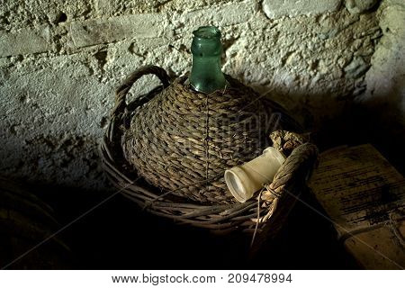 old straw-covered demijohn with aged red wine