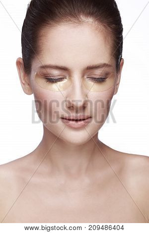 portrait of a girl on a white background with patches for the eyes
