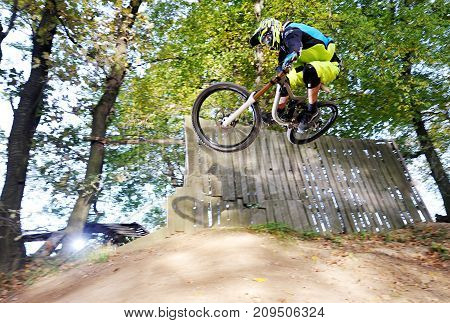 Biker jumping in Bohemian forest, small bikepark in Prague