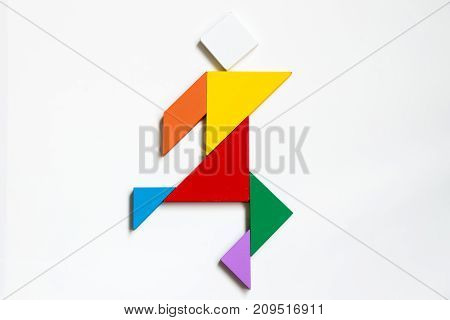 Color wood tangram puzzle on human walking shape on white background