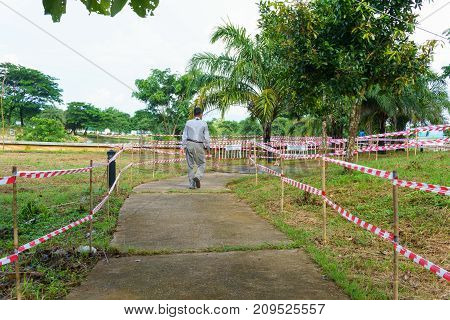 Cement Path Way With Red And White Tripped Tape Fence For Barricades Or Restrcited Zones Or Forbidde