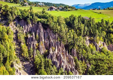 The concept of world tours. Renon's earth pillars at sunrise. Small mountain village in the Italian Tirol. Journey to the magic country