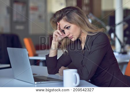 Young and beautiful businesswoman tired from work in the office.Woman holding her head