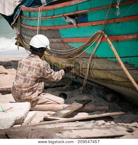 Samila Beach Songkhla Thailand - March 23 2017: Fishermen are repairing fishing boat on Samila beach.