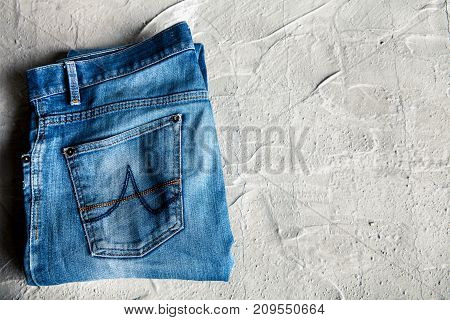 gray jeans on a concrete background (top view)