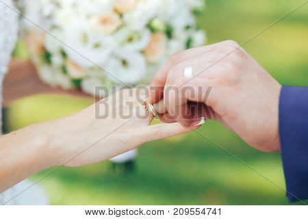 Wedding rings on the hands of the newlyweds