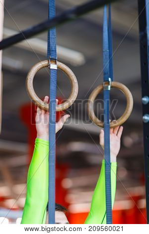 Young athlete with gymnastic rings in the gym. Close-up. The concept of sport.