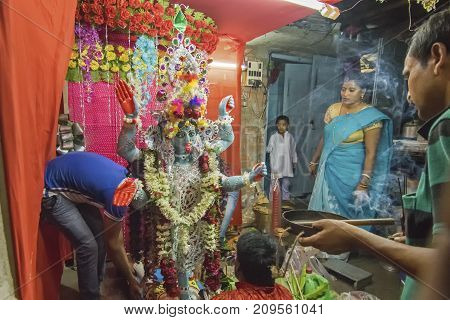 KOLKATA INDIA - JUNE 17 2017 - Hindu devotees worshipping Goddess Kali at night during Kali Puja Hindu festival of Deepavali or Diwali. Celebtated all over India. Shot under mixed light.