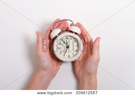Classic Alarm Clock in a hand. Concept anyone with time on hand equal. At 12 o'clock
