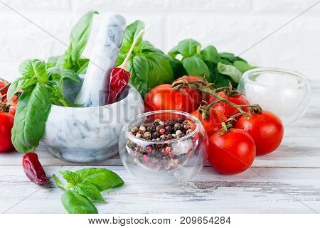 Tomatoes And Bunch Of Fresh Green Basil On A White Wood Background,