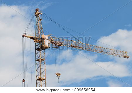 Big yellow stationary hoist on construction site blue sky and white clouds