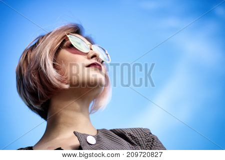 Stylish and beautiful woman looking up at sky.