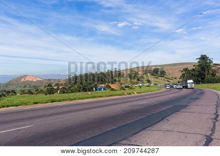 Trucks and vehicles on steep road highway hill climb in countryside landscape.