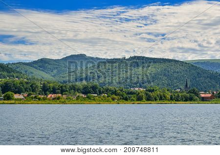 Summer mountain landscape. River and village in the mountains.