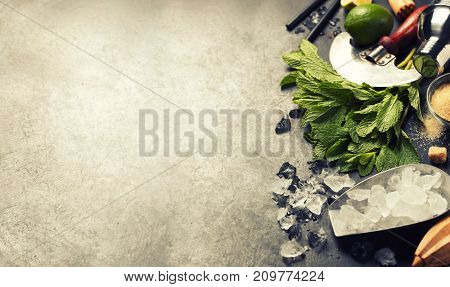 Mojito cocktail ingredients (fresh mint, lime, ice) on rustick background