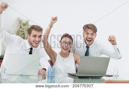 Team of three work colleagues with their arms raised in celebrat