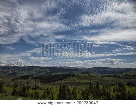 Snow capped Rocky Mountain Valley on a cloudy spring day