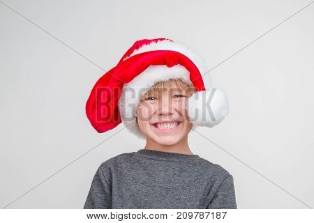 Horisontal emotional portrait of caucasian boy with santa hat. horizontal photo